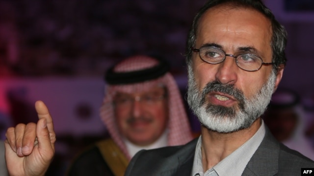 Ahmed Mouaz al-Khatib gestures after he was elected to lead the National Coalition of Forces of the the Syrian Revolution and Opposition on November 11.