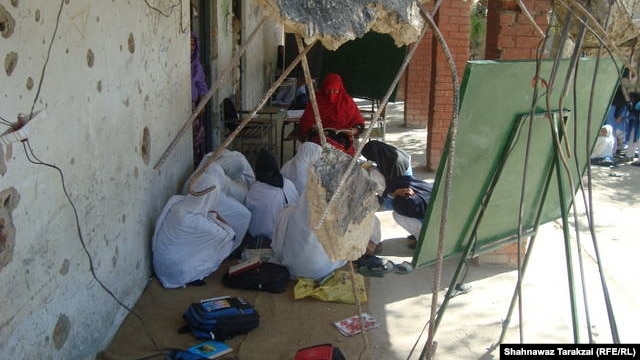 Students and a teacher of a destroyed girls school in Bajaur Agency hide their faces from the camera.