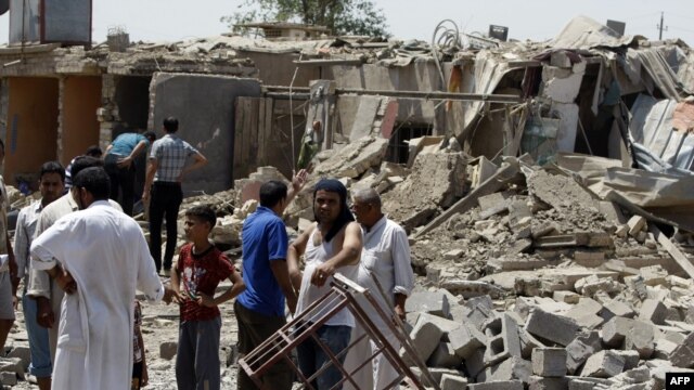 Iraqis stand amid the rubble of destroyed houses following a series of Al-Qaeda bomb attacks in the town of Taji, north of Baghdad which killed at least 42 people last month.
