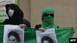 Opposition supporters hold pictures of Ayatollah Khomeini during a protest at Tehran University
