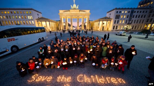 Demonstrators call for the international community to "Save the Children in Syria" and hold a minute of silence in front of the Brandenburg Gate in Berlin on March 14. 