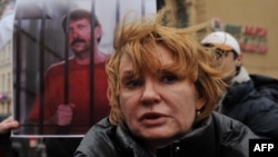 Alla Bout, wife of jailed Russian arms dealer Viktor Bout, stands in front of his photo as she attends a protest in front of the U.S. Consulate in St. Petersburg in 2011.
