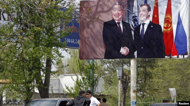 A billboard in southern Kyrgyzstan, where the ethnic violence has killed at least 170 people and injured many hundreds more, shows Russian President Dmitry Medvedev with the now-deposed Kyrgyz leader Kurmanbek Bakiev in April 2010.