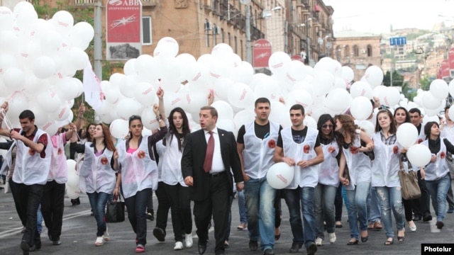 Armenia - A senior member of the ruling Republican Party escorts young party activists to an election campaign rally in Yerevan's Republic Square, 4May2012.