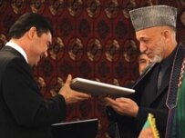 Afghan President Hamid Karzai (right) and his Turkmen counterpart, Gurbanguly Berdymukhammedov, exchange one of their agreements in Kabul (AFP)