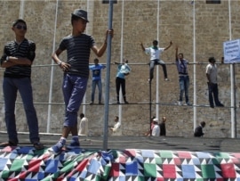 Libyan men stand during a protest after Friday prayers in Green Square, downtown Tripoli, July 8, 2011