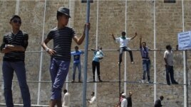  Libyan men stand during a protest after Friday prayers in Green Square, downtown Tripoli, July 8, 2011 
