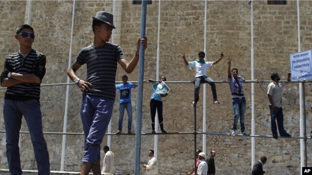  Libyan men stand during a protest after Friday prayers in Green Square, downtown Tripoli, July 8, 2011 