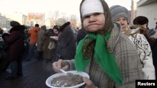A woman eats a plate of boiled buckwheat during a street event in St. Petersburg. Russians on January 27 marked the end of the 872-day siege of Leningrad in 1943, which claimed the lives of more than 500,000 people.