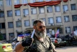 Пророссийский активист с ножом стоит у здания местной администрации. Краматорск, 7 июня 2014 года.