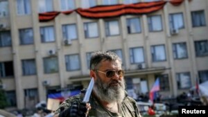Пророссийский активист с ножом стоит у здания местной администрации. Краматорск, 7 июня 2014 года.