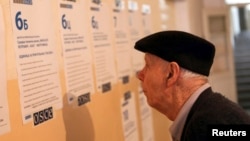 A man reads balloting instructions at a polling station in Kosovo's ethnically divided town of Mitrovica before casting his vote in the Serbian elections on March 16.