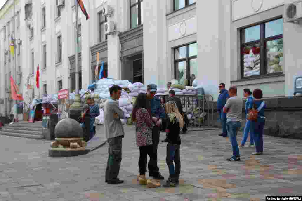 People stand outside the regional administration building.