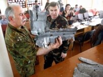 Military observers inspect debris purportedly from an unmanned Georgian reconnaissance plane (ITAR-TASS)