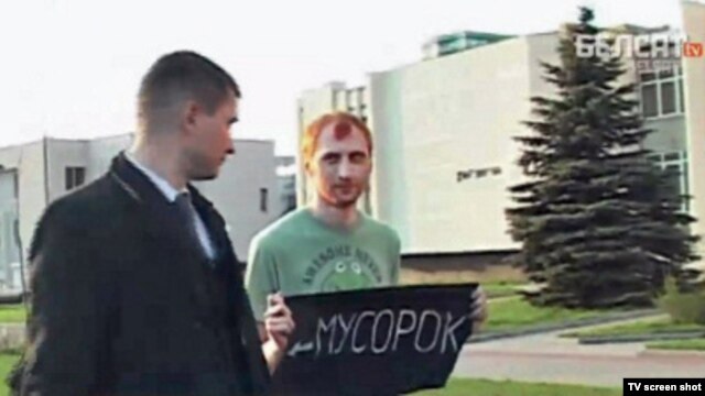 Activist Ivan Amelchanka (right) pictured with the offending sign