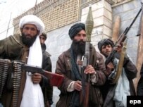 Former Taliban fighters attend a ceremony as they surrender their weapons.