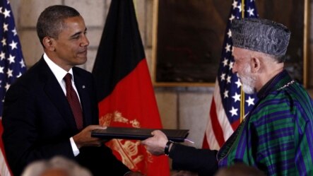 Afghan President Hamid Karzai (right) and his U.S. counterpart Barack Obama exchange documents after signing a Strategic Partnership Agreement at the Presidential Palace in Kabul on May 2.