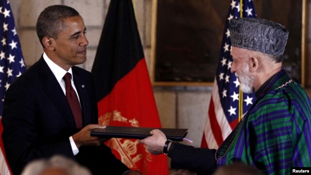 Afghan President Hamid Karzai (right) and his U.S. counterpart Barack Obama exchange documents after signing a Strategic Partnership Agreement at the Presidential Palace in Kabul on May 2.