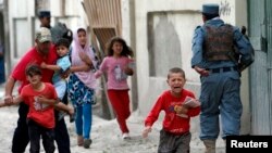 Children flee as security forces respond after several large explosions hit a busy downtown area of Kabul on May 24.