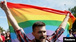 Мужчина с радужным флагом в день шествия ЛГБТ. Иллюстративное фото.