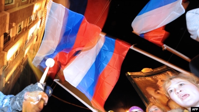 Pro-Kremlin youth activists wave the Russian flag as they rally in Moscow.