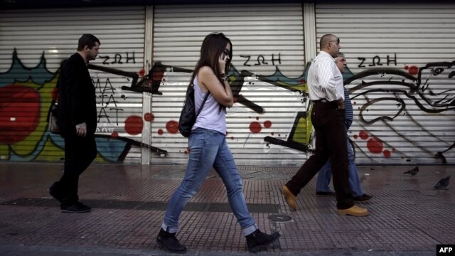 People walk outside a closed post office in Athens on the first day of Greece's 48-hour general strike on November 6.