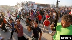In Baghdad, members of a Shi'a militia parade through the streets.