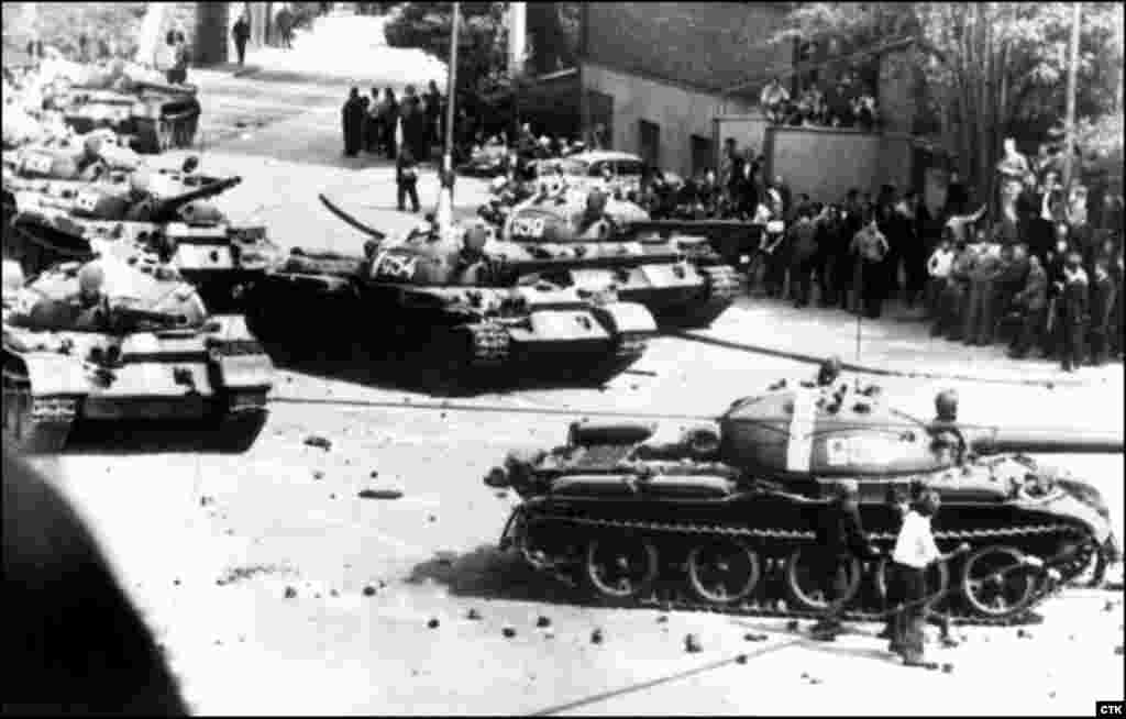 Protesters throw stones at the Soviet tanks entering Prague.