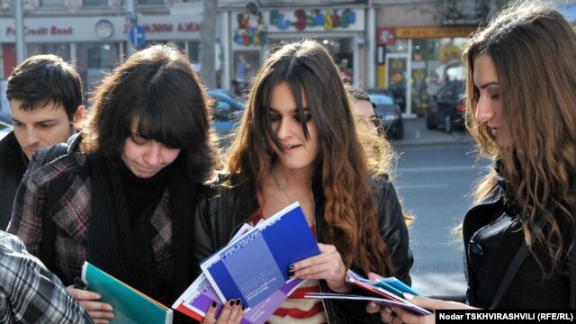 Representatives of Transparency International distribute copies of the corruption report to students in Tbilisi as part of Anticorruption Day activities.