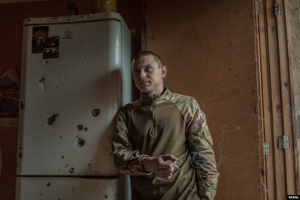 Posing next to a bullet-riddled fridge, this is "Chikatilo" -- nicknamed after a Soviet-era serial killer. Before the war, he was a taxi driver.