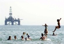 Azerbaijan – Energy – Azeri children swim in the Caspian Sea a few kilometers from an offshore oil rig, close to where the new Baku-Tbilisi-Ceyhan (BTC) oil pipeline is being constructed, 11Aug2003