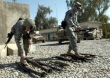 Iraq -- US soldiers count weapons confiscated after clashes between joint forces and insurgents, in Ba'qubah, 11 May 2006