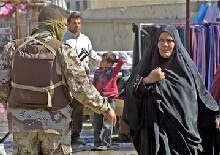 Iraq -- An Iraqi soldier gestures to a woman not to approach the site where a roadside bomb exploded in central Baquba city, northeast of Baghdad, 23 Feb. 2006