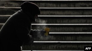 An elderly woman begs for alms in sub-zero temperatures at a subway entrance in Kyiv, Ukraine, on February 8. 