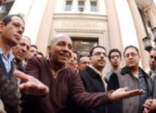 Egypt – Business / finance – Small investors outside the Cairo Stock Exchange discuss the continuing drop in the value in once-booming stocks the Arab world, 14 March 2006. (Size: 220x155.) Source:epa.