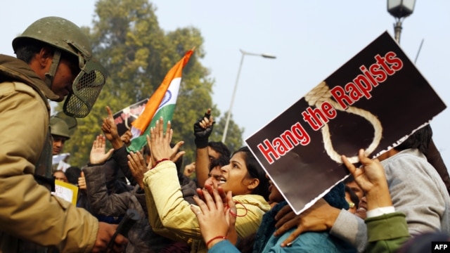 A demonstrator taunts police during a protest calling for improved safety for women following the gang rape and killing of a woman on a bus in New Delhi.