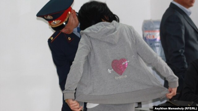 Сотқа қатысушыны тексеріп тұрған полиция қызметкері. Ақтау, 23 сәуір 2012 жыл.