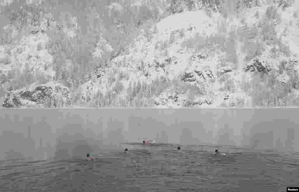 Members of a local winter swimming club take part in their weekly bath in the Yenisei River while air temperatures stood at minus 17 degrees Celsius in the town of Divnogorsk, outside Russia's Siberian city of Krasnoyarsk. (Reuters/Ilya Naymushin)