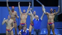 Serbia's bench celebrates a goal against Australia during their quarterfinal water-polo match.