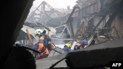Eemergency services work amid the debris of a shopping mall, which was razed by fire in Kazan.