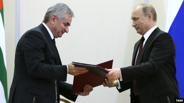  Abkhazian leader Raul Khajimba (left) and Russian President Vladimir Putin exchange documents during the signing ceremony at the Bocharov Ruchei residence in Sochi on November 24.