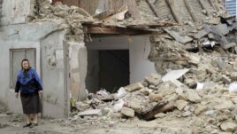 A woman stands near a demolished house in Baku last month.