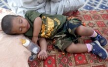 Iraq - An Iraqi child sleeps inside his family's tent at a refugee camp for Iraqi families, in Baghdad, 29Jun2006