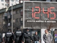 Kosovo -- Kosovo police officers patrol near a billboard that reads 