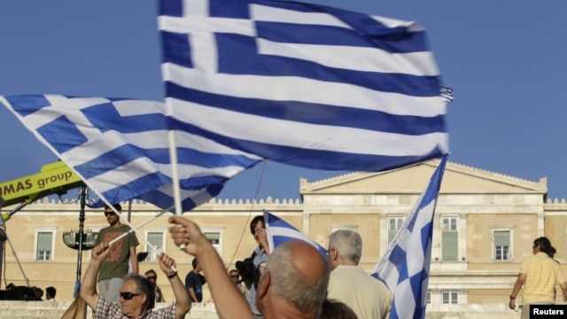 A man holds a Greek flag before a conservative New Democracy party rally on Syntagma Square in Athens on June 15. 