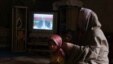 An Iranian woman and her child watch one of the three televised presidential debates in early June.