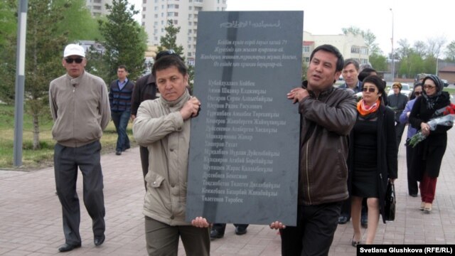 Астанада оппозиция белсенділері мемлекеттік рәміздер алаңында Жаңаөзен құрбандарының аты жазылған қара мрамор тақтаны әкеле жатыр. Астана, 28 сәуір 2012 жыл.