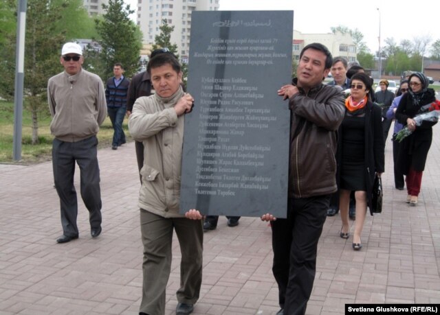 Гражданские активисты несут мемориальную плиту в память погибших в Жанаозене. Астана, 28 апреля 2012 года.
