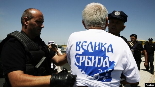 Police detain a Serb wearing a T-shirt reading "Greater Serbia" during a celebration of the anniversary of the 1389 Battle of Kosovo Polje at Gazimestan on June 28.