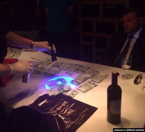 The Investigative Committee shared photographs of Nikita Belykh at a restaurant as investigators shined ultraviolet flashlights at an alleged bribe of 400,000 euros.